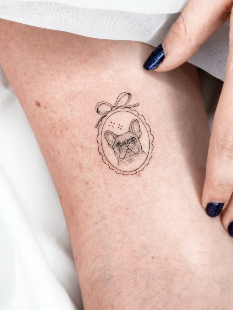 French Bulldog pendant tattoo located on the ankle, illustrative style.