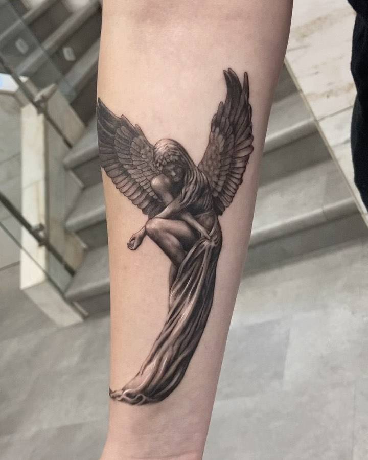 Angel tattoo in black and grey style placed on the inner forearm.