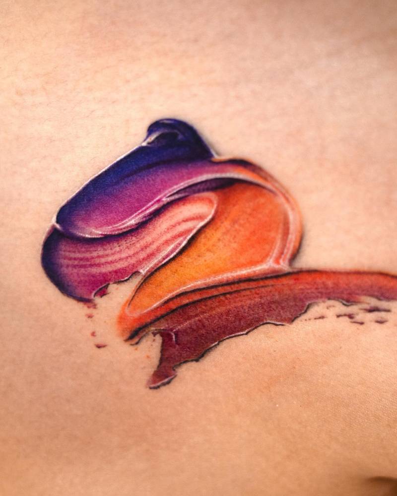 Watercolor style brush stroke tattoo located on the shoulder.