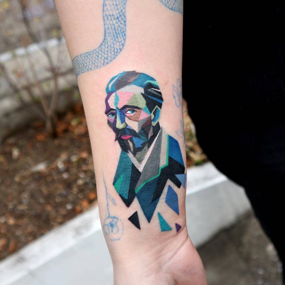 Geometric style Van Gogh portrait tattoo located on the wrist.