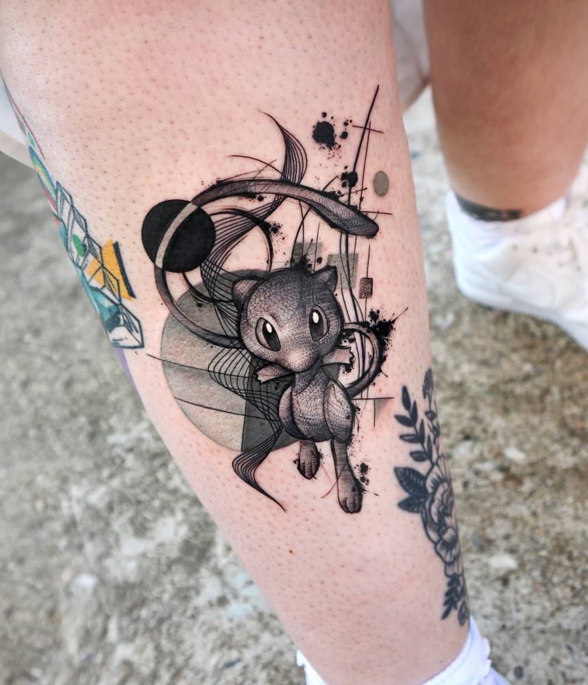 Mew tattoo in graphic style located on the shin.