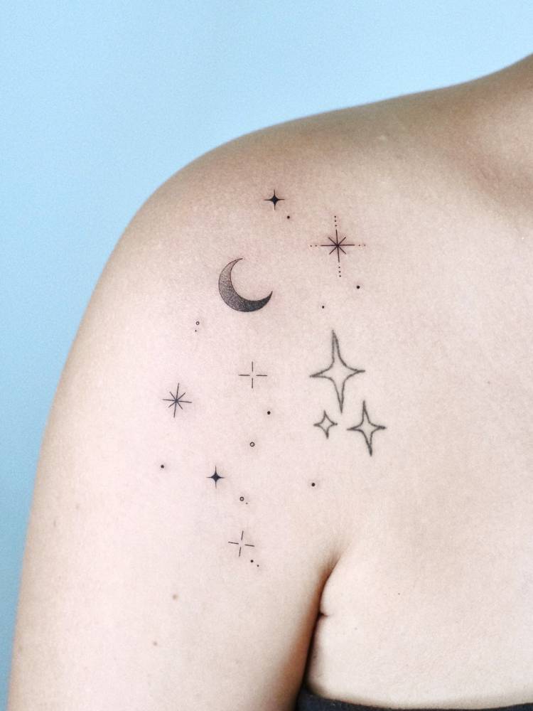 Sparkling stars and crescent moon tattoo placed on the shoulder.
