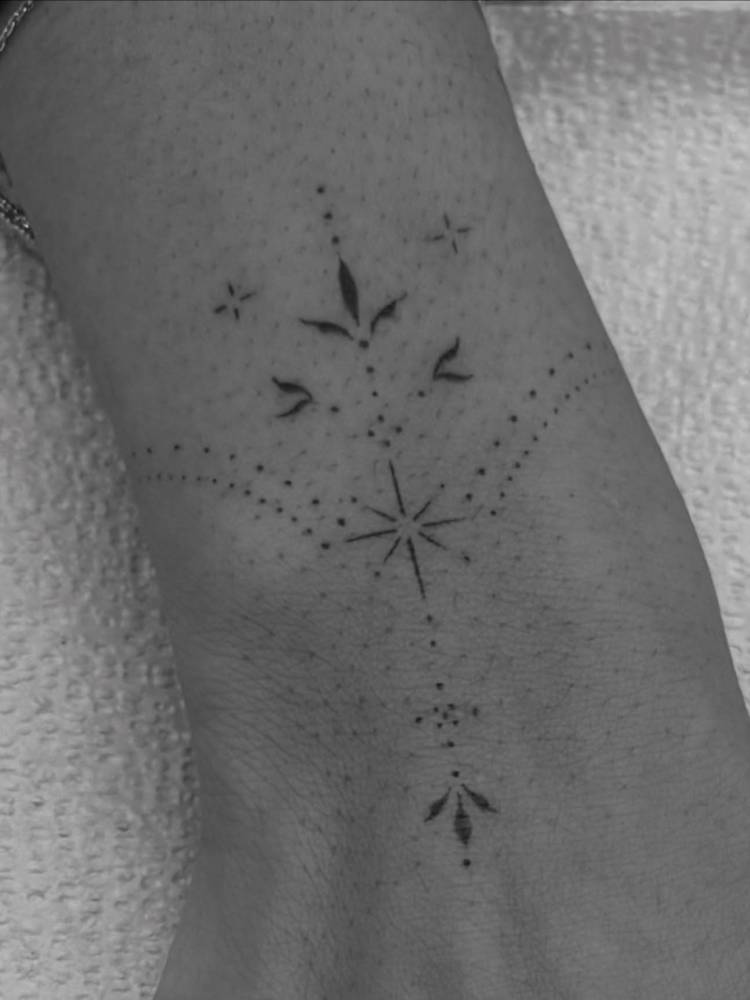 Ornamental tattoo design located on the wrist.