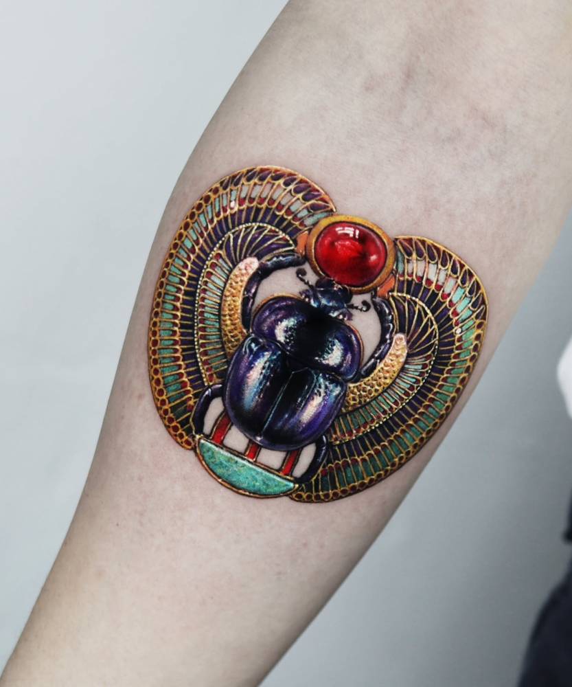 Scarab tattoo in micro-realistic style placed on the inner forearm.