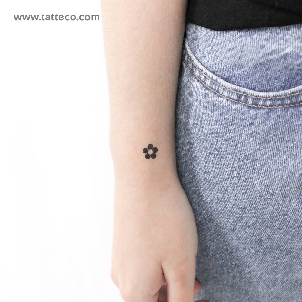 Minimalist tiny flower temporary tattoo located on the wrist.