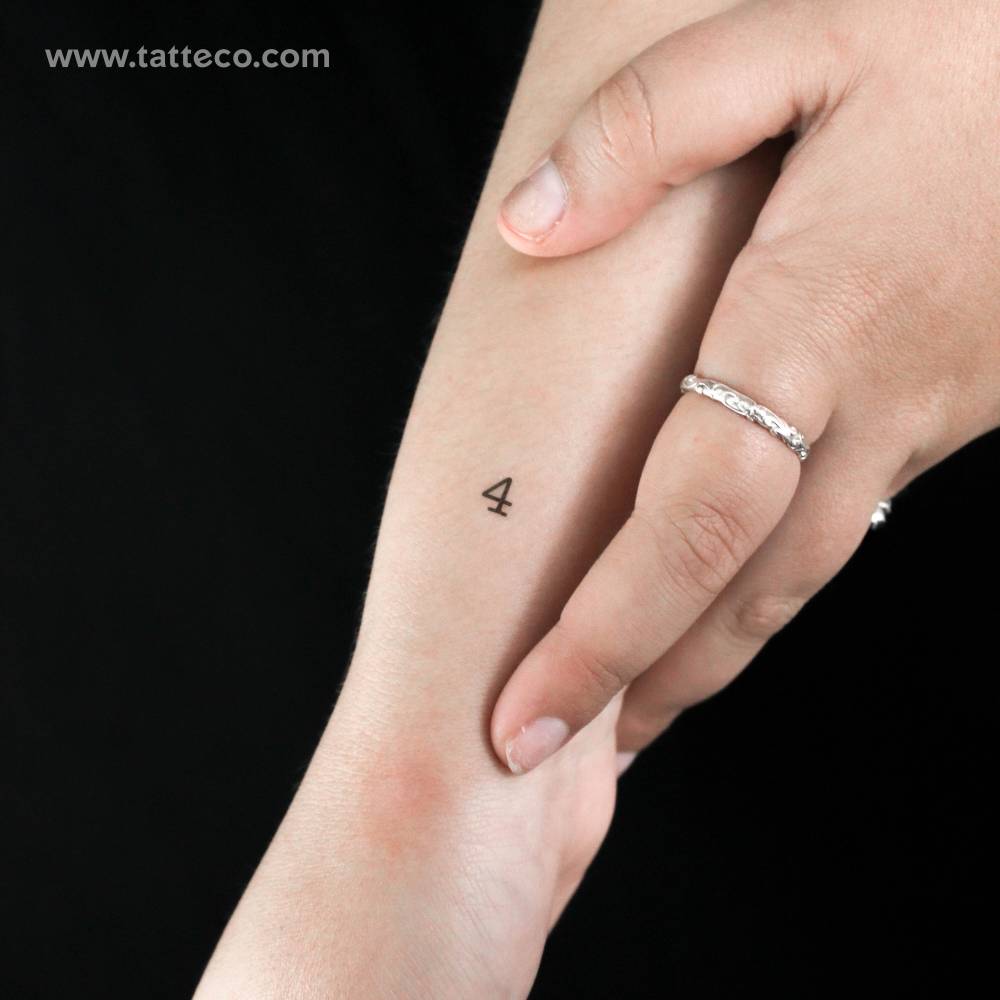 Typewriter font number "4" temporary tattoo placed on the wrist.