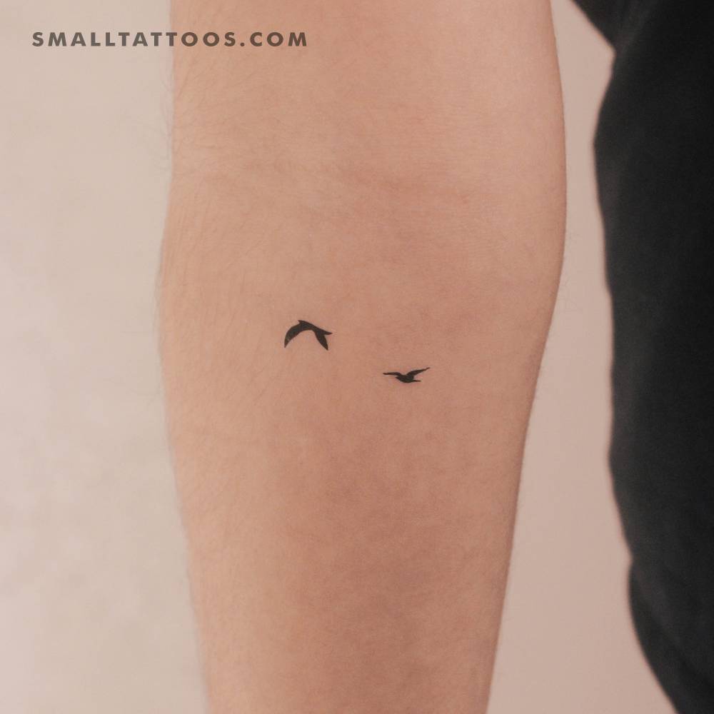 Two flying birds temporary tattoo located on the inner forearm.