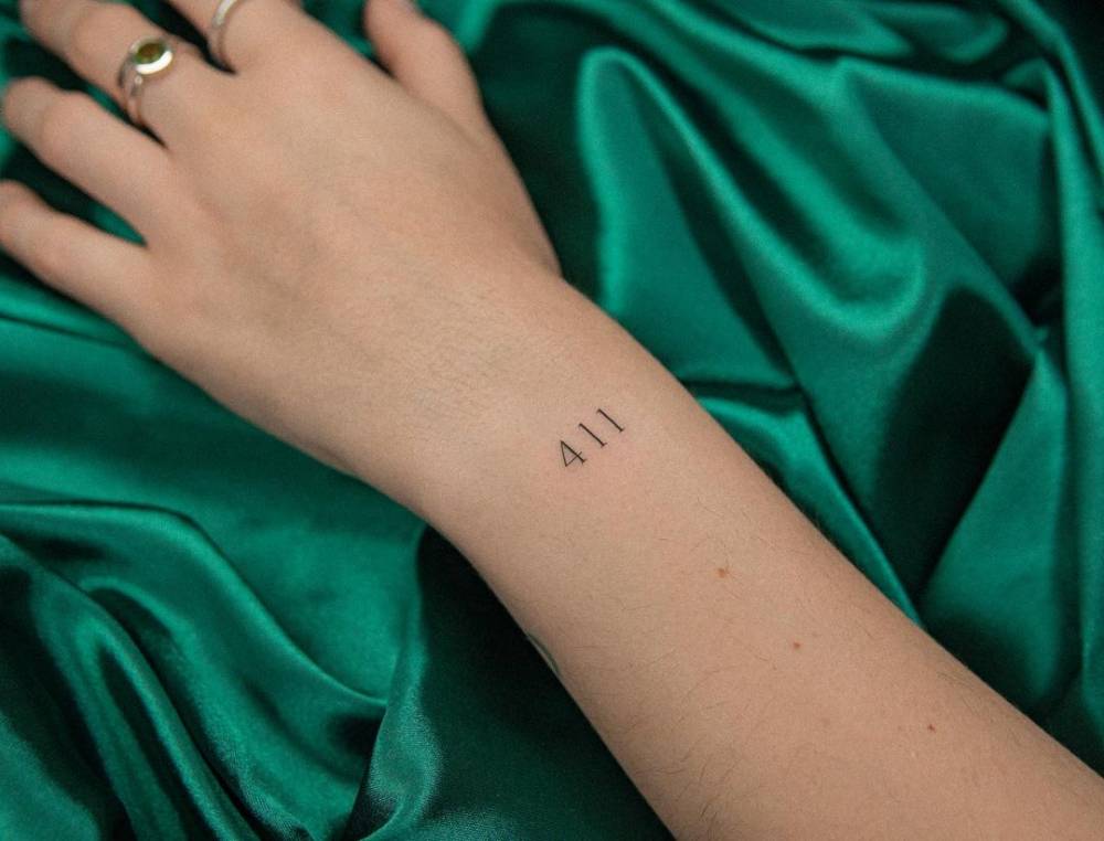 Tattoo of the number "411" placed on the wrist.