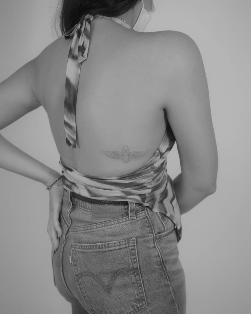 Scarab tattoo in fine line style located on the back.