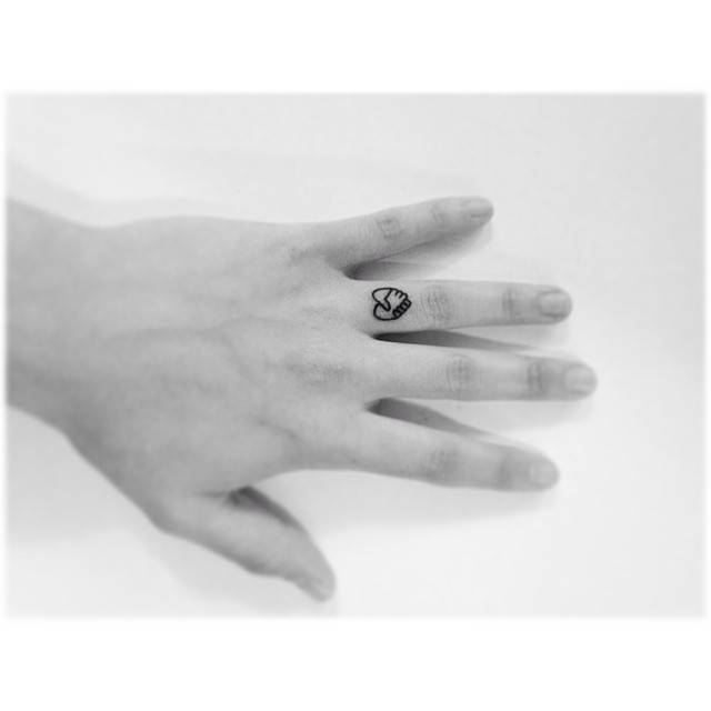 Holding hands heart tattoo located on the finger, minimalistic style.