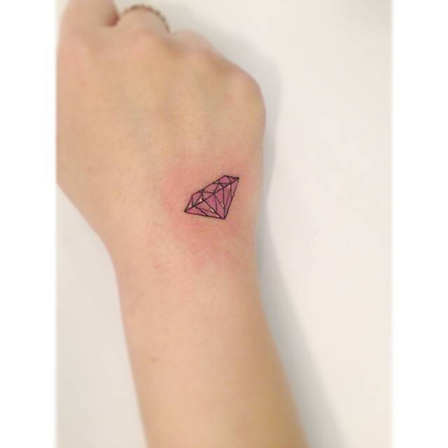 Diamond tattoo in illustrative style located on the hand.