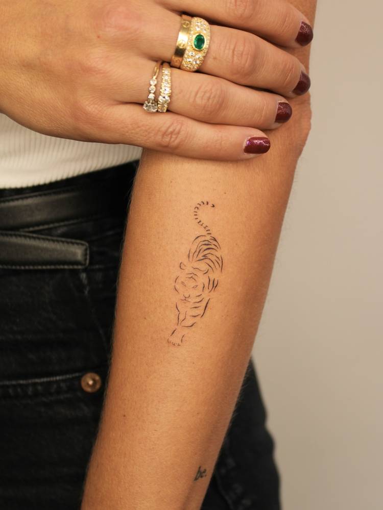 Fine line style tiger tattoo located on the forearm.