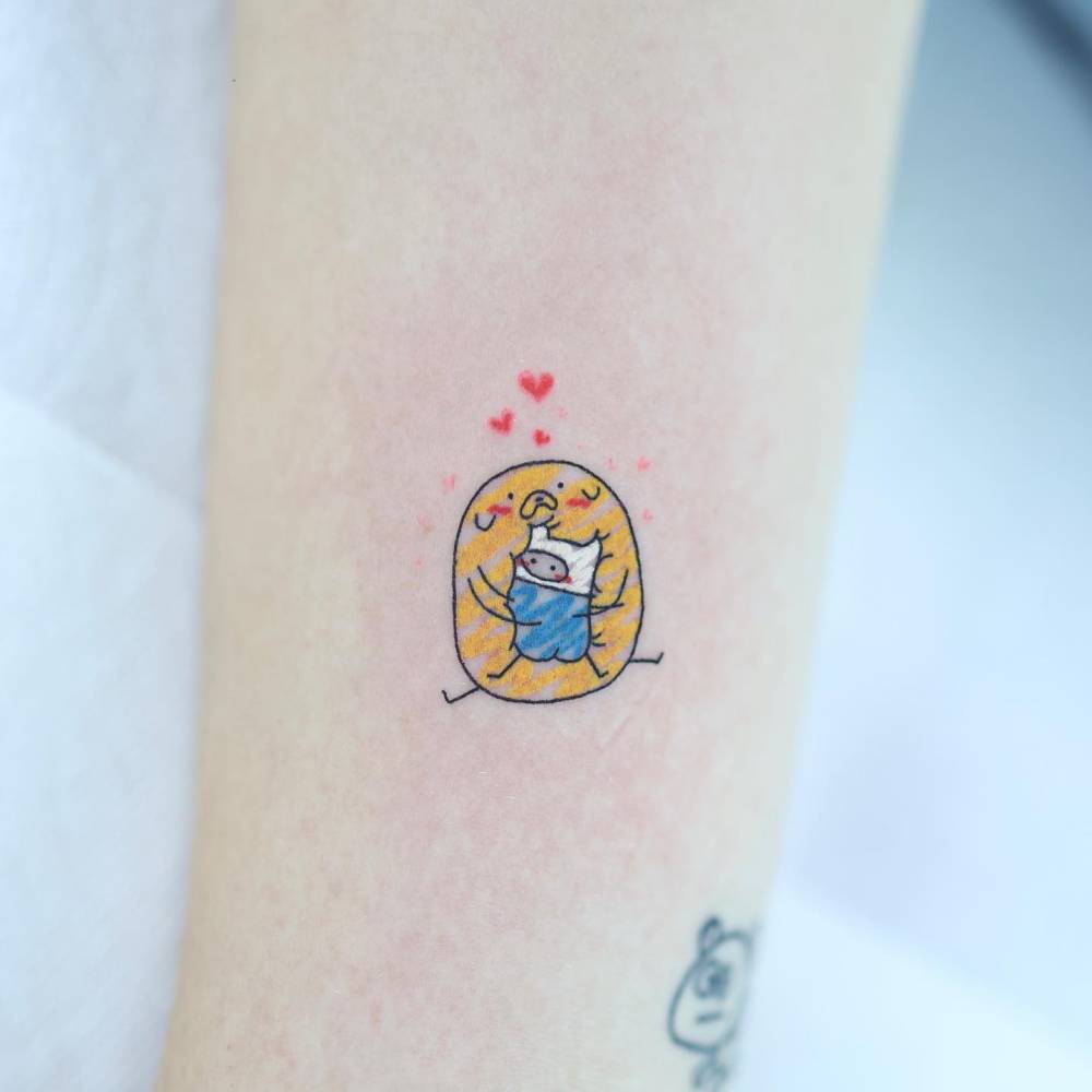 Jake and Finn hugging tattooed on the inner forearm.