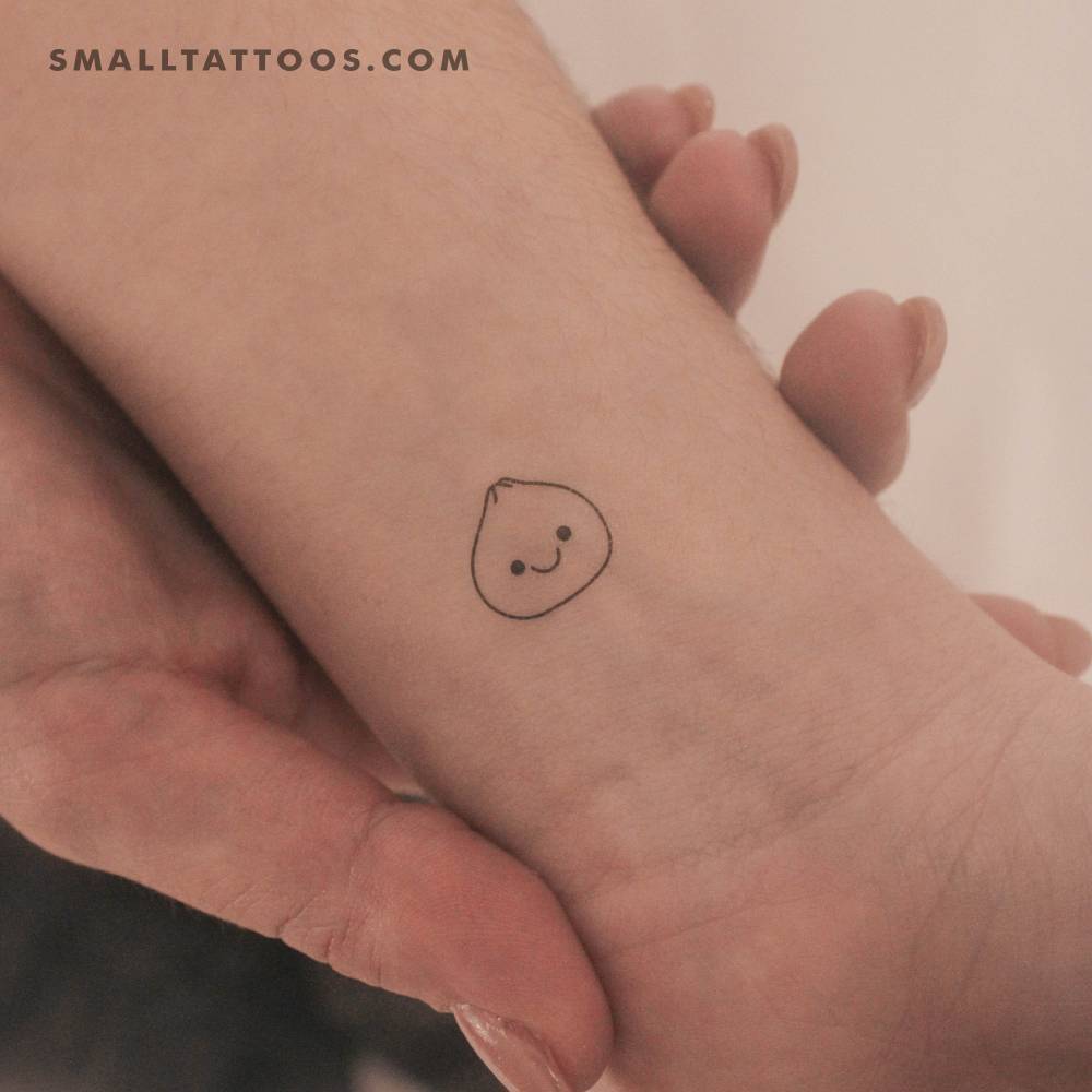 Tiny minimalistic dumpling temporary tattoo located on the wrist.