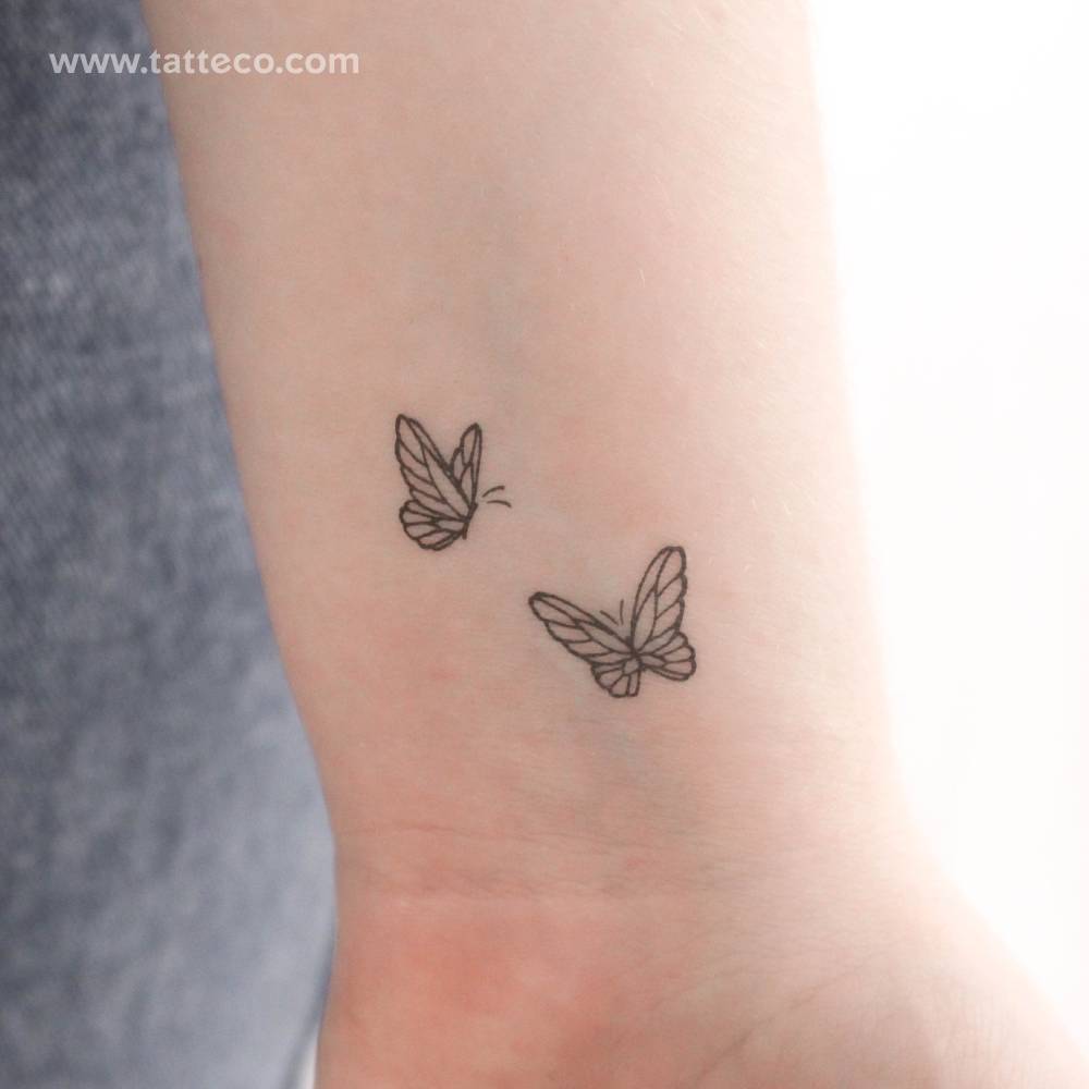 Delicate butterfly duo temporary tattoo located on the wrist.