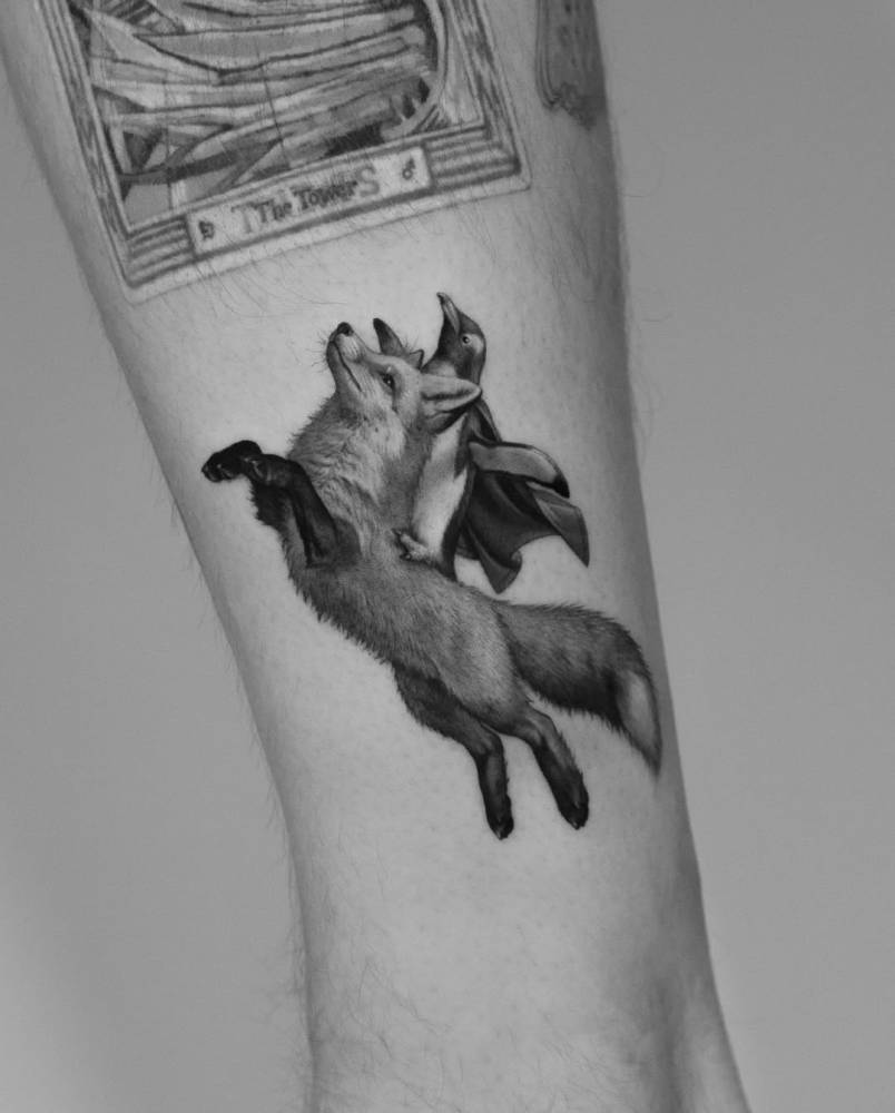 Fox and penguins tattoo in micro-realistic style located on the shin.