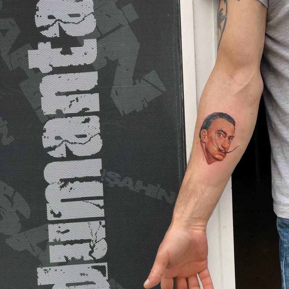 Salvador Dali portrait tattoo in micro-realistic style done on the inner forearm.