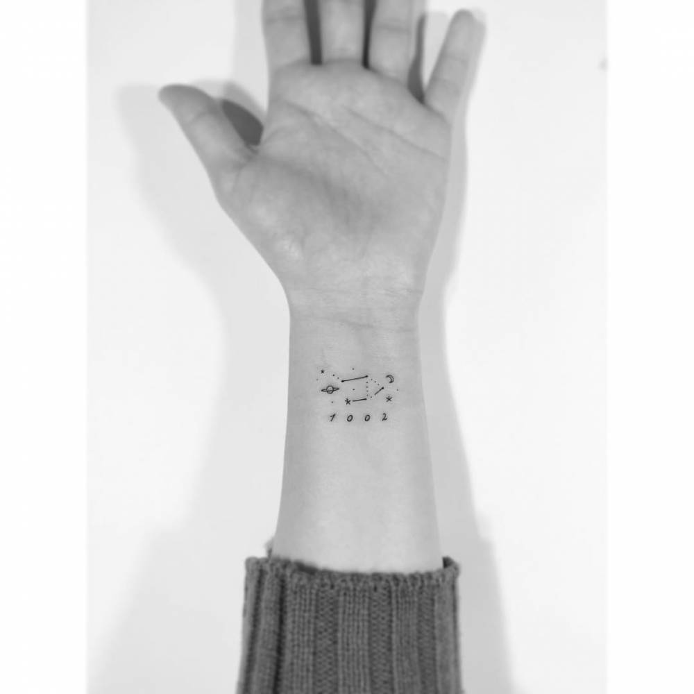 Libra constellation tattoo in minimalistic style located on the wrist.