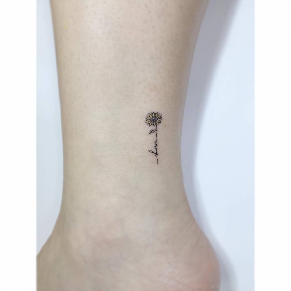 Sunflower and name "Lee" tattoo placed on the ankle.
