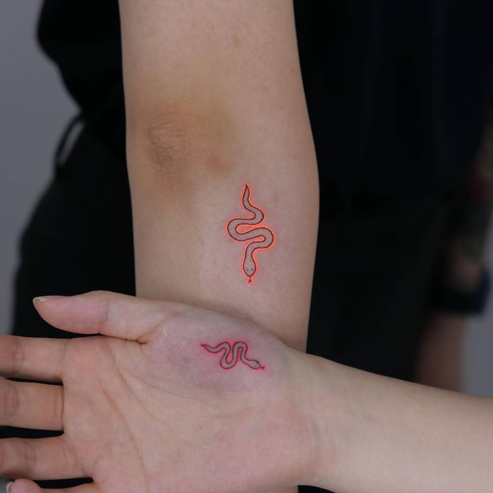 Matching minimalistic style snake tattoo in UV ink for best friends.
