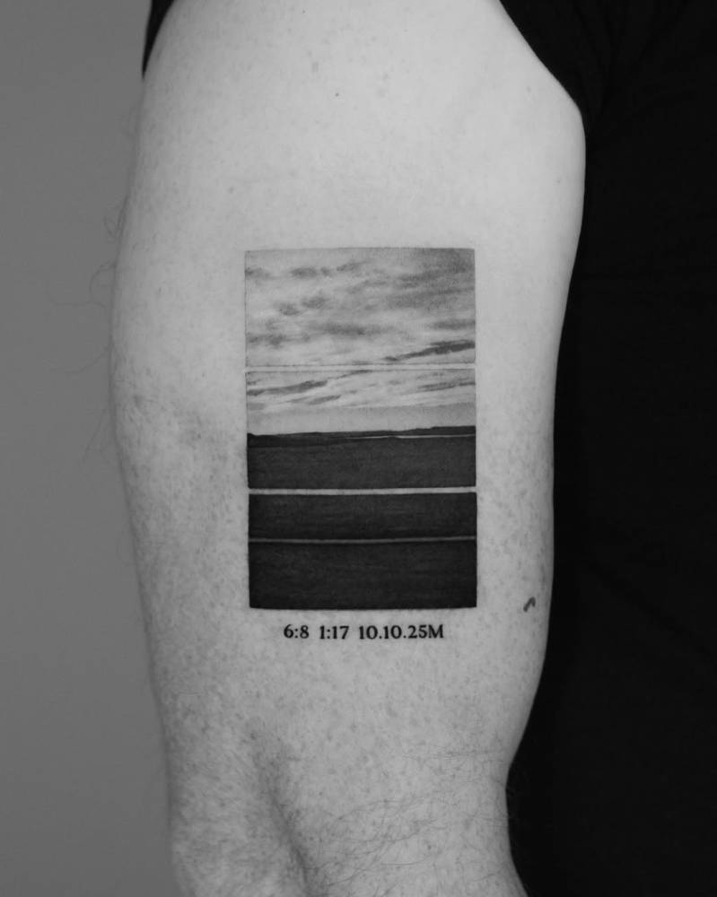 Landscape and time tattoo located on the upper arm.