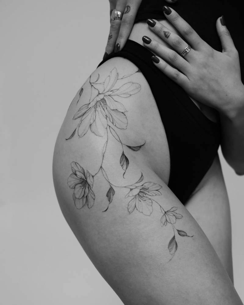 Magnolias tattoo located on the hip, done in illustrative style.