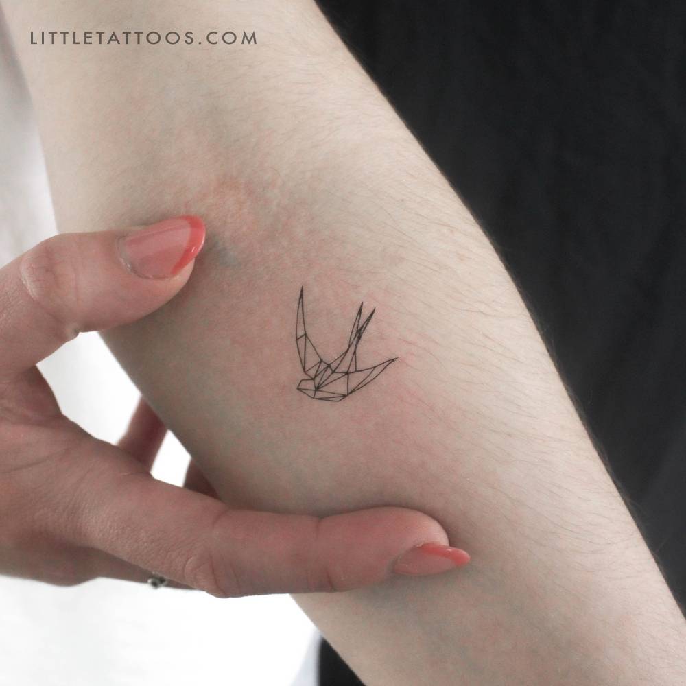 Low poly swallow temporary tattoo placed on the inner forearm.