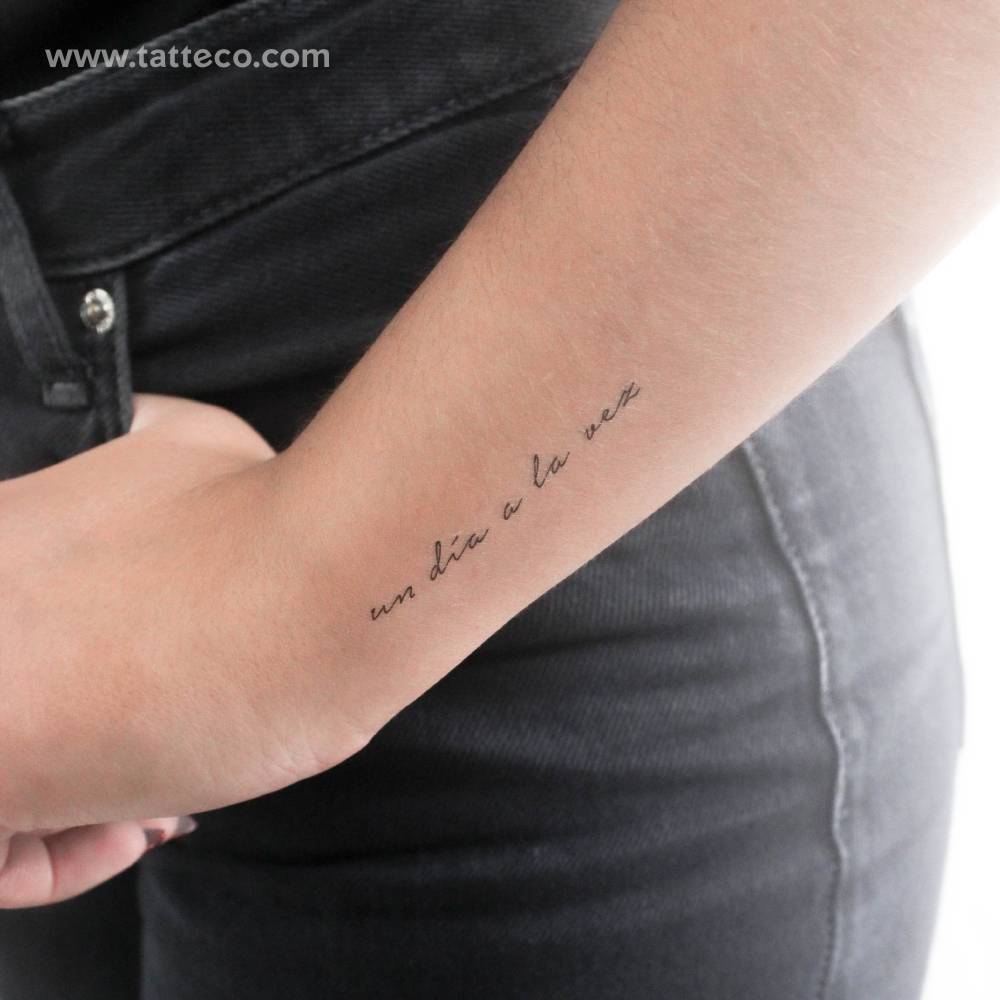 Handwritten font "un día a la vez" temporary tattoo located on the wrist.