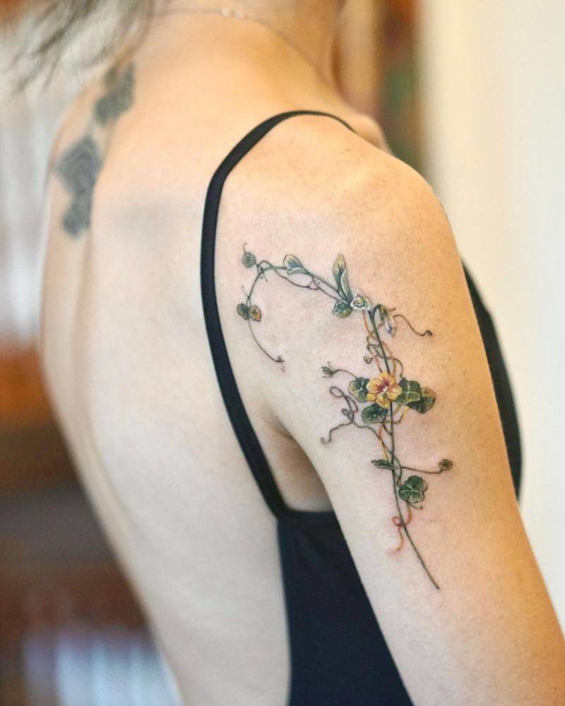 Nasturtium vines tattooed on the upper arm.