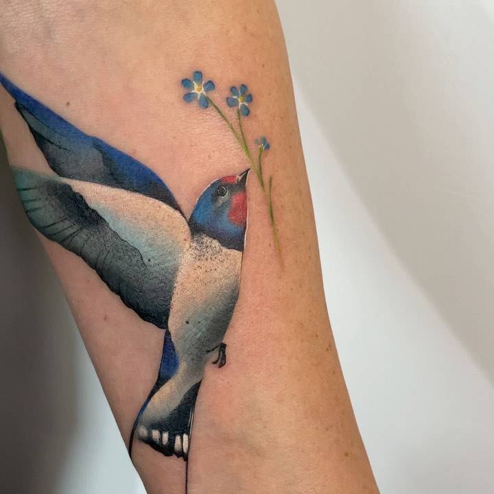 Watercolor style swallow tattoo done on the inner forearm.