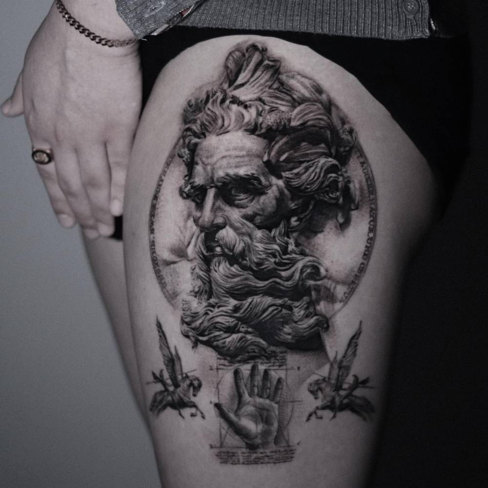 Black and grey 'Bust of Neptune' tattoo located on the thigh.