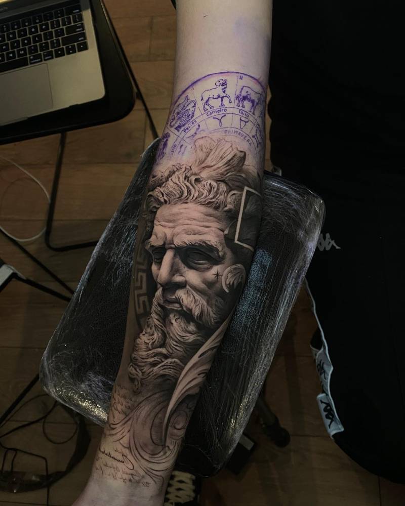Bust of Neptune tattoo located on the inner forearm, black and grey style.