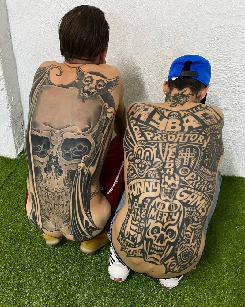 Bat and skull and Lettering backpiece tattoos.