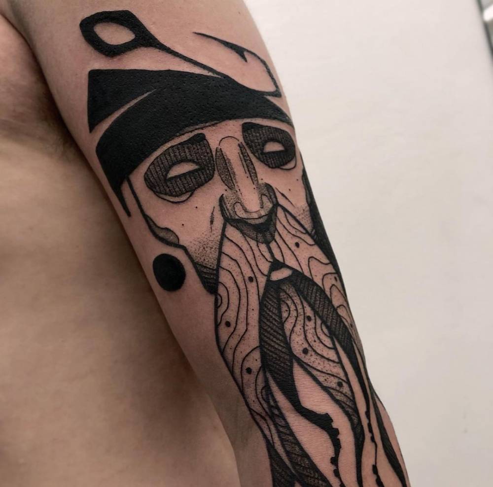 Blackwork fisherman portrait tattoo on the arm.