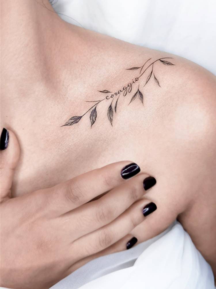 Leaves and word "coraggio" tattooed on the collarbone.