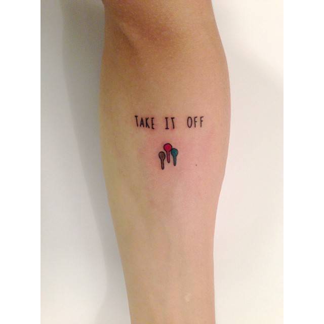 "Take it off" lettering tattoo located on the inner forearm.