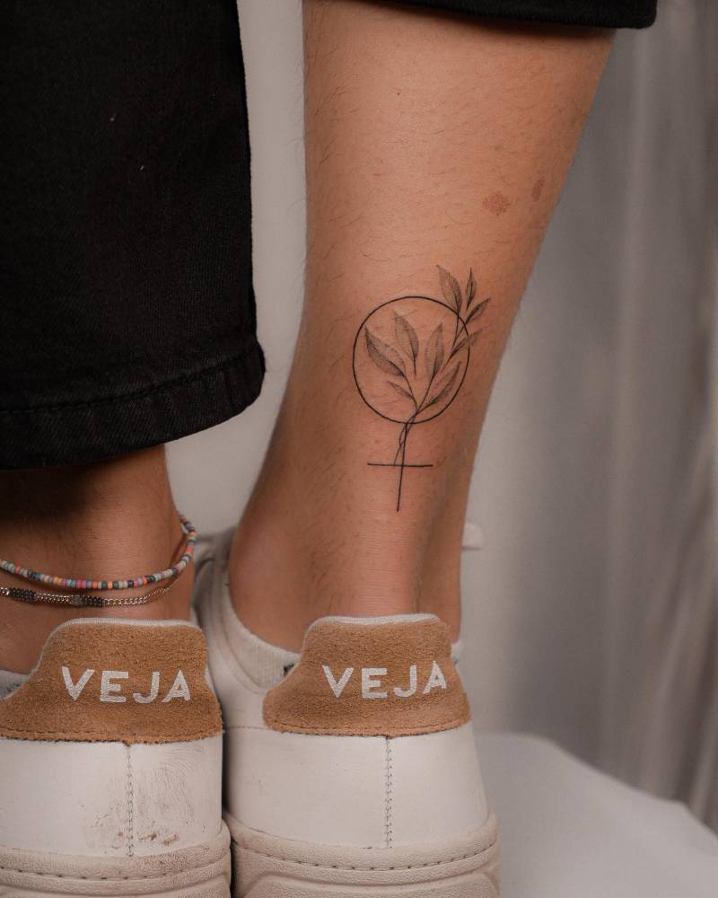 Venus symbol and leaves tattoo done on the achilles.