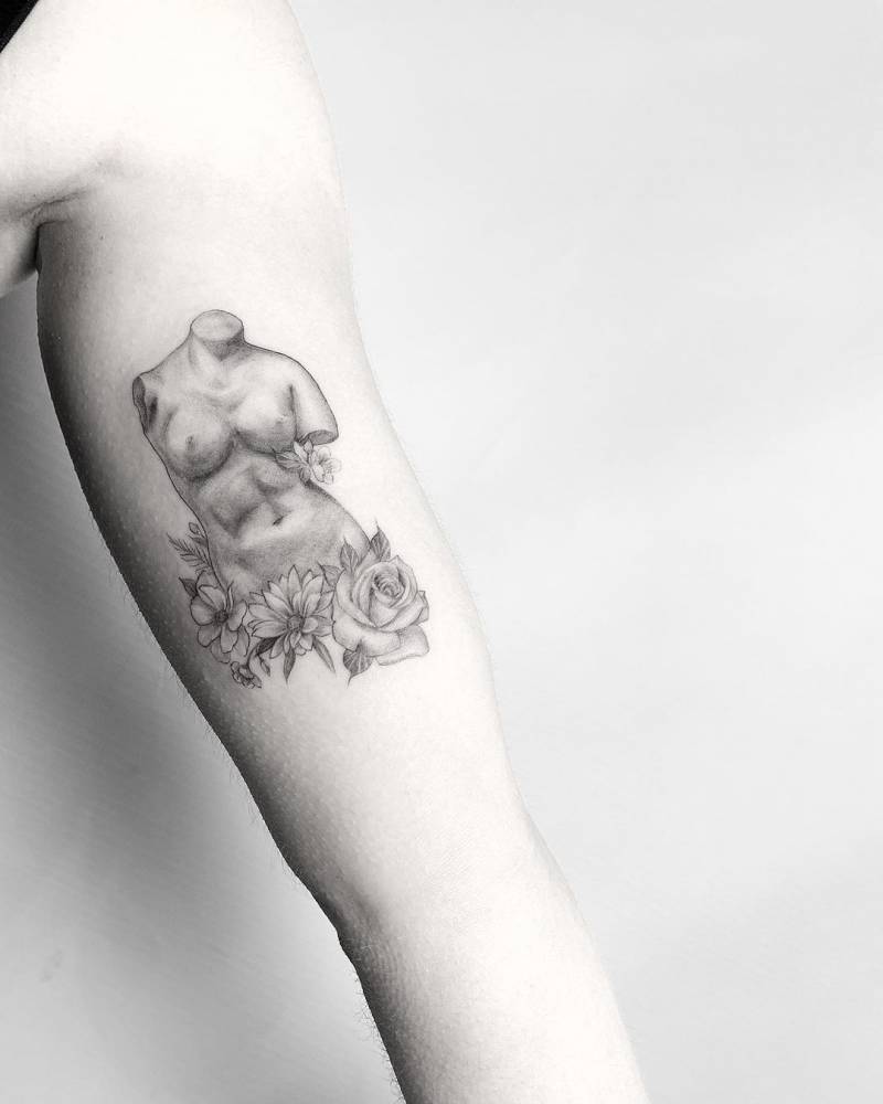 Micro-realistic Venus de Milo tattoo on the inner arm.