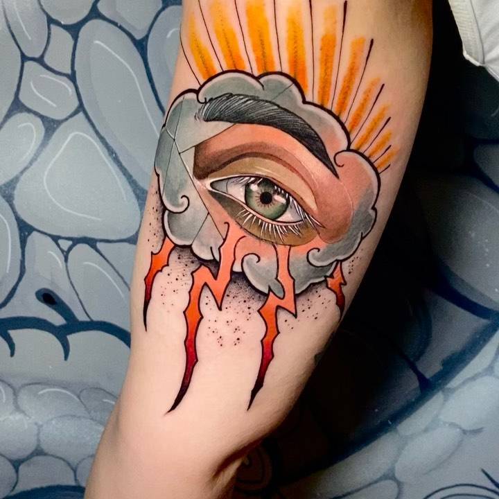 Neotraditional eye and cloud tattoo on the inner arm.