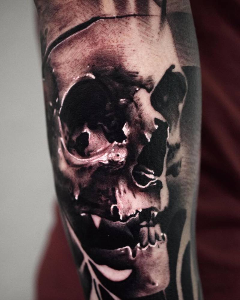 Black and grey skull tattoo on the forearm.