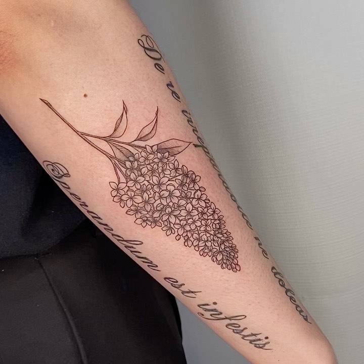 Fine line lilacs tattoo on the forearm.