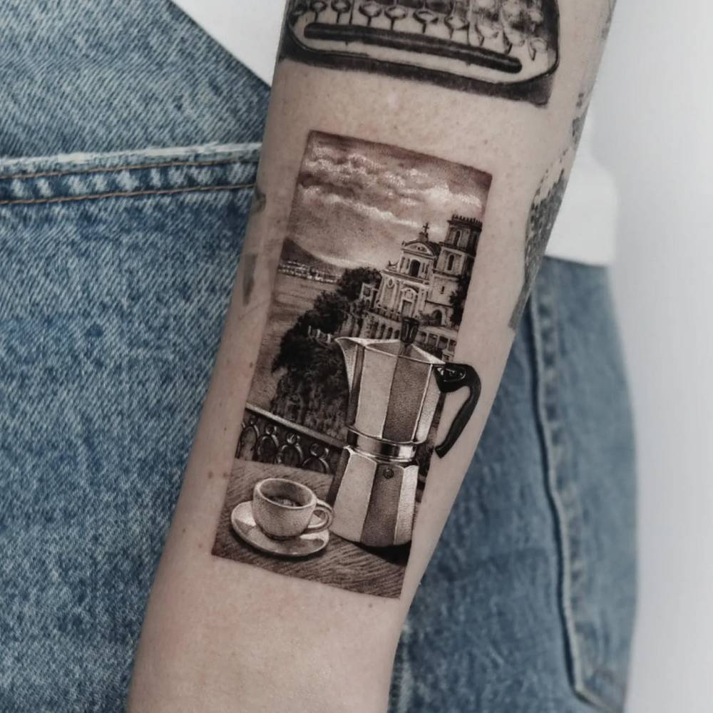 Moka pot and landscape tattoo located on the forearm.