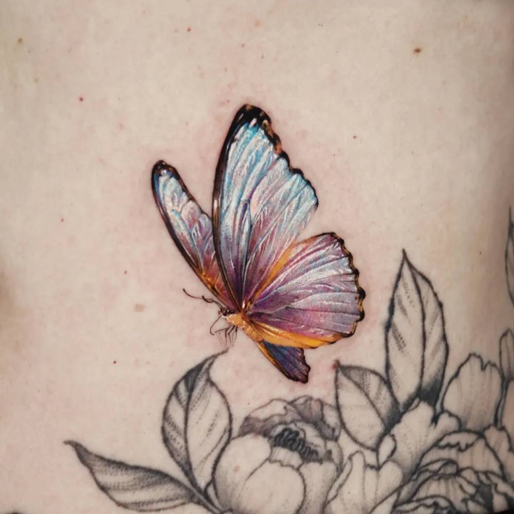 Butterfly tattoo done on the waist, micro-realistic style.