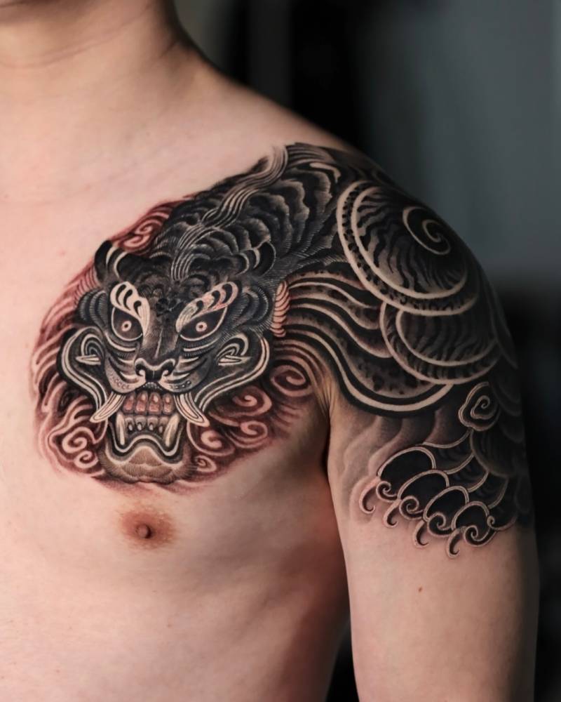 Tiger tattoo located on the shoulder, done in oriental style.