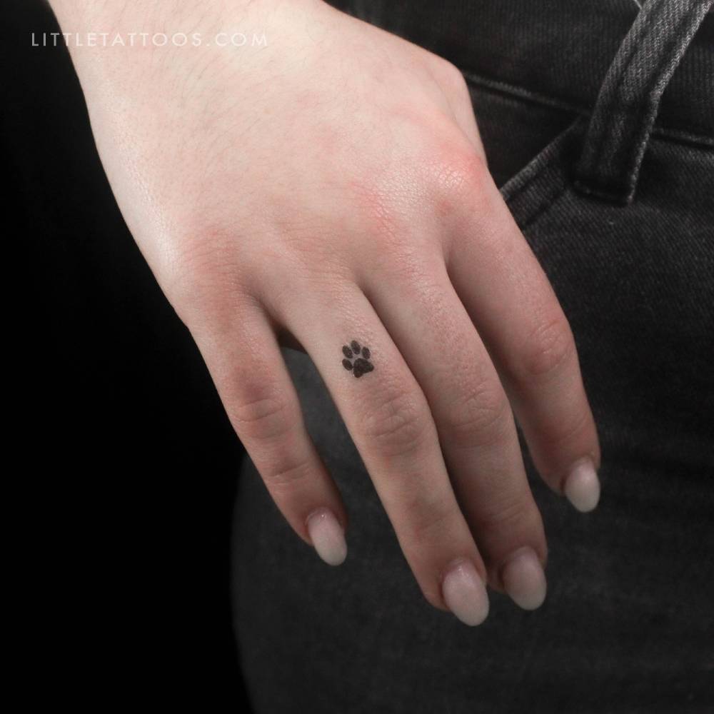 Tiny minimalistic dog paw print temporary tattoo located on the finger.