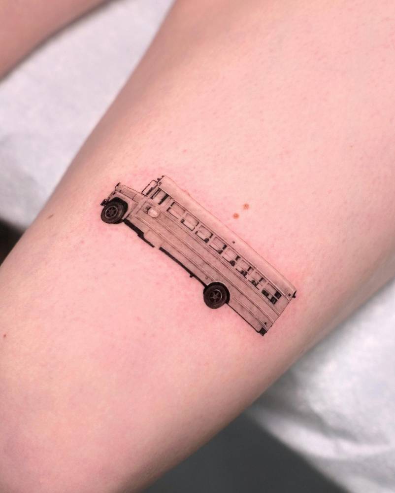School bus tattoo located on the thigh, micro-realistic style.