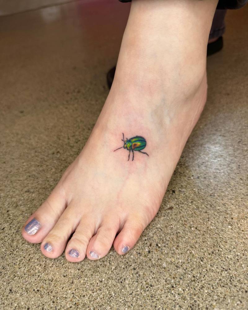 Illustrative style beetle tattoo placed on the foot.