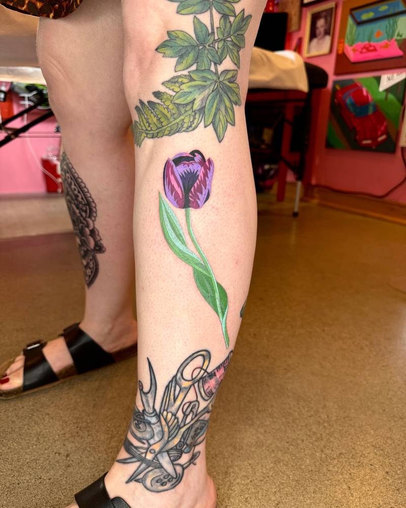 Illustrative style tulip tattoo located on the shin.