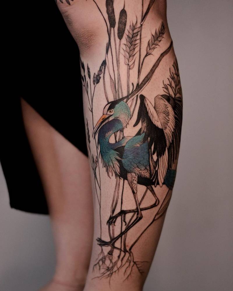 Heron and meadow plants tattoo on the leg