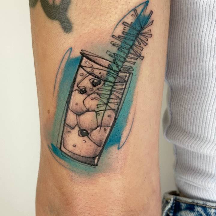 Sketchy style gin tonic tattoo on the tricep.